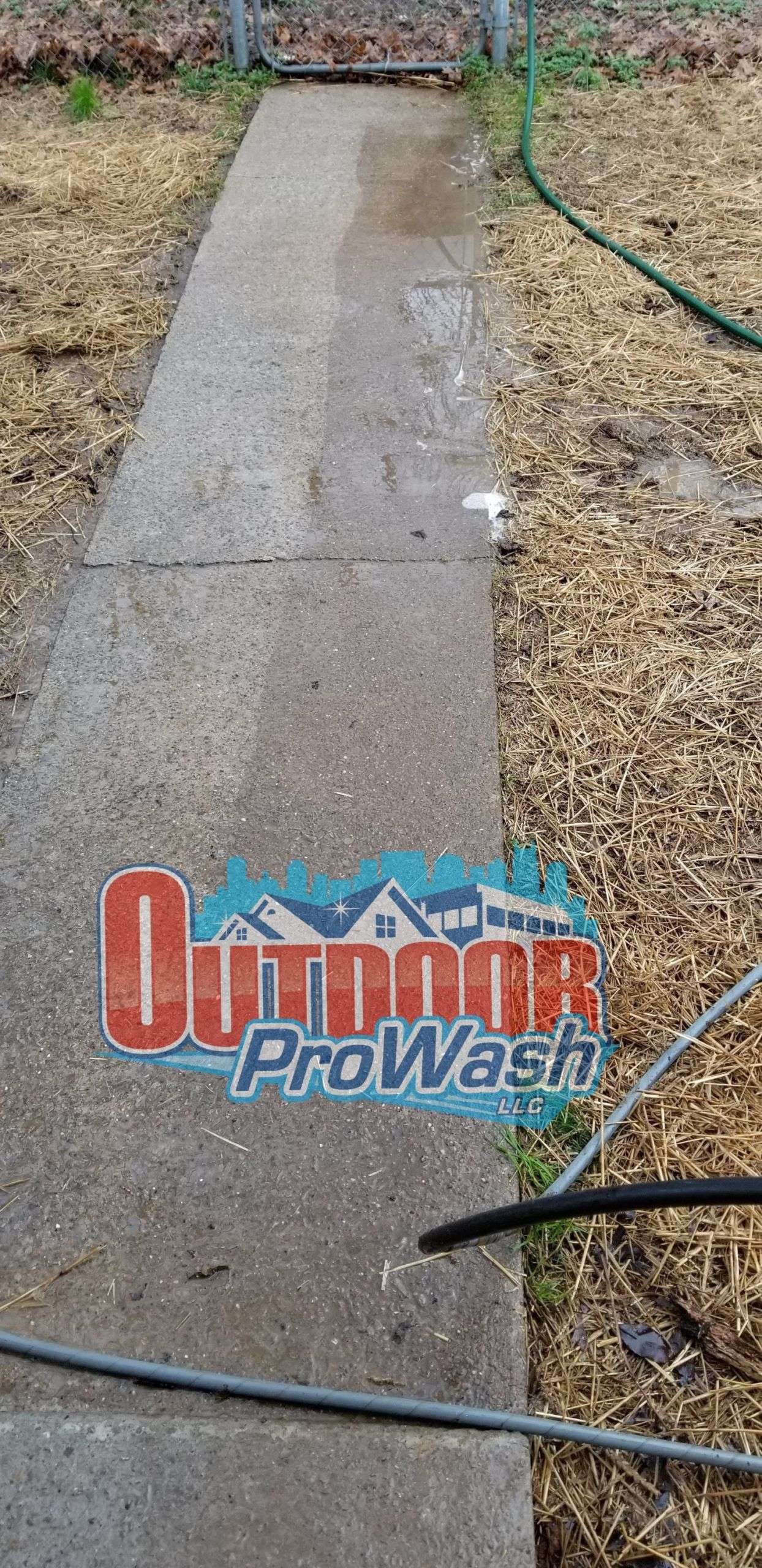 A sidewalk with grass and a sign that says outdoor prowash.